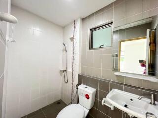 Modern bathroom with shower area, toilet, and sink