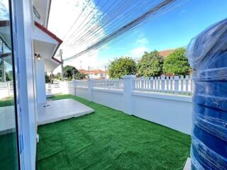 Backyard with artificial grass and white picket fence