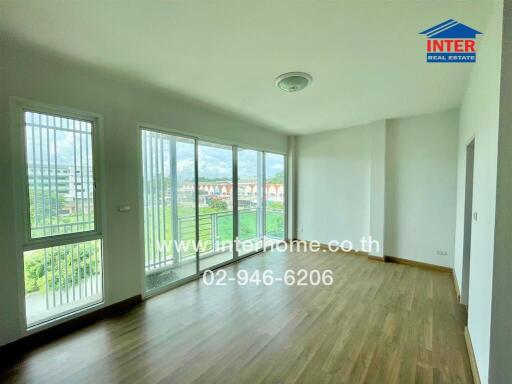 Spacious living room with large windows and balcony
