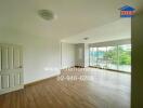 Spacious living room with wooden flooring and large windows