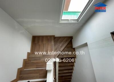 Staircase with wooden steps and white walls