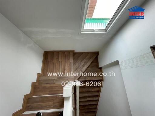 Staircase with wooden steps and white walls