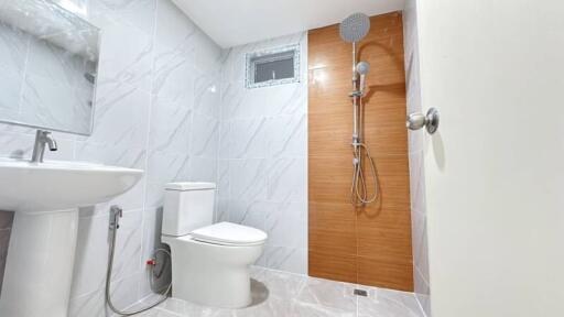 Modern bathroom with toilet, shower, and sink