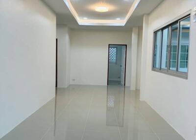 Spacious living room with modern tiled flooring and decorative ceiling light