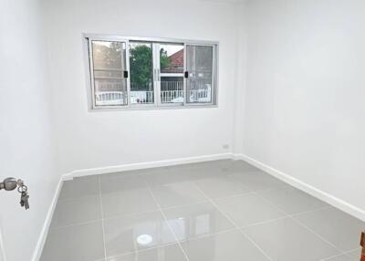 Empty bedroom with large windows and tiled floor
