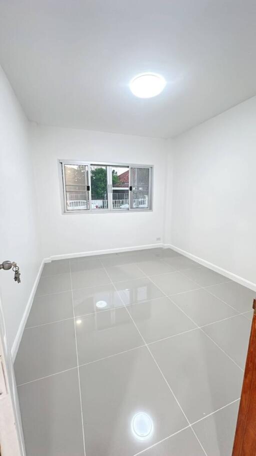 Empty bedroom with large windows and tiled floor