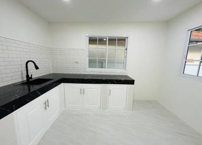 Modern Kitchen with White Cabinets and Black Countertops