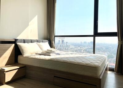 Cozy bedroom with a large window and city view