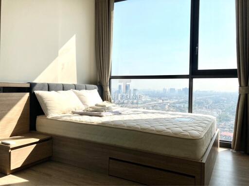 Cozy bedroom with a large window and city view