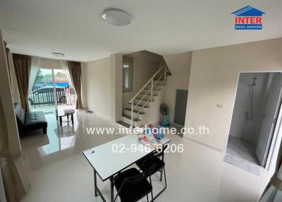 Spacious living area with dining space and stairs