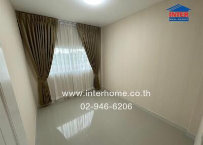 Empty bedroom with tiled floor, large window with curtains, and light-colored walls.