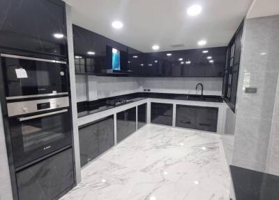 Modern kitchen with marble flooring and black cabinetry