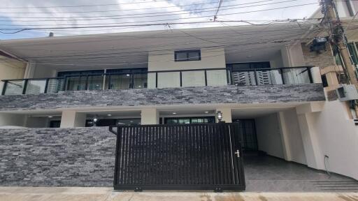 Front view of a modern building with stone facade and gated entrance