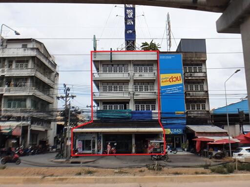 Front view of a multi-story commercial building with retail space on the ground floor