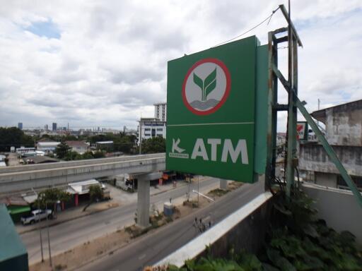 View of an ATM sign and a cityscape in the background