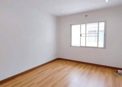 Empty bedroom with wooden floor and bright window