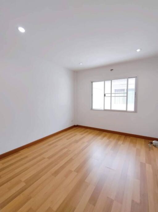 Empty bedroom with wooden floor and bright window