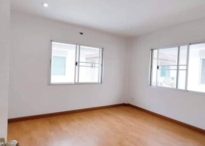 Empty bedroom with wooden floor and windows