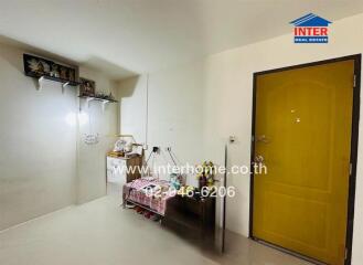 Hallway with bright yellow door and shelves