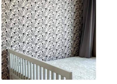 Bedroom with crib and patterned wallpaper