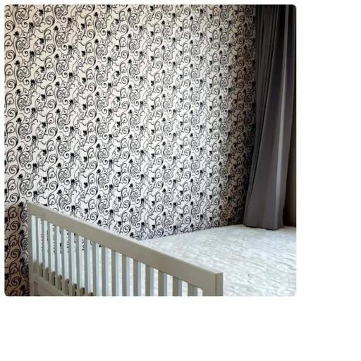 Bedroom with crib and patterned wallpaper