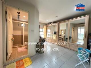 Living room with large mirrored wardrobes, visible bathroom, and various furnishings