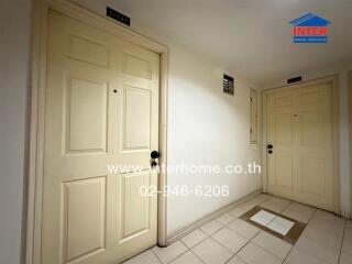 Apartment hallway with two doors and tile flooring