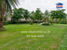 Spacious green lawn with trees and a few benches