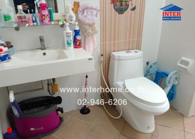 Bathroom with sink, toilet, and various hygiene products