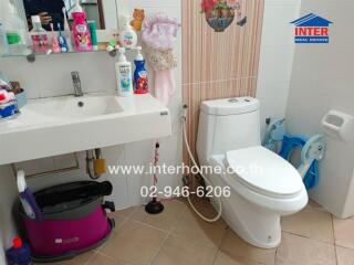 Bathroom with sink, toilet, and various hygiene products