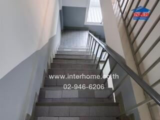 Staircase with metal railing and tiled steps