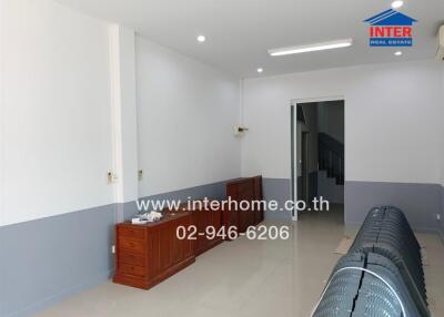 Spacious living area with minimal furniture and air conditioning