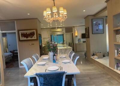 Spacious dining area with elegant chandelier and six-seater dining table