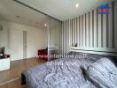 Bedroom with wooden floor, bed, and striped wallpaper