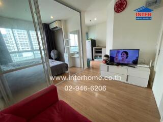 Living room with a view of an adjacent bedroom and a television