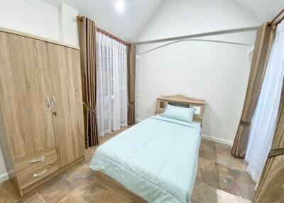 bright and spacious bedroom with single bed, wardrobe, and large windows