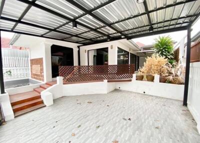 Covered outdoor patio with tiled floor and wooden accents