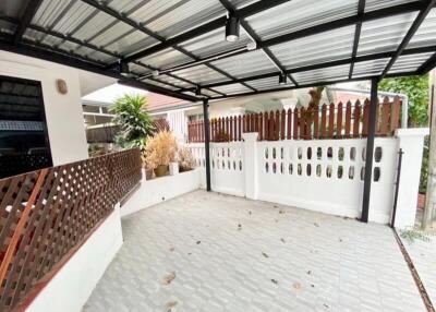 Covered outdoor area with tiled floor and decorative fencing