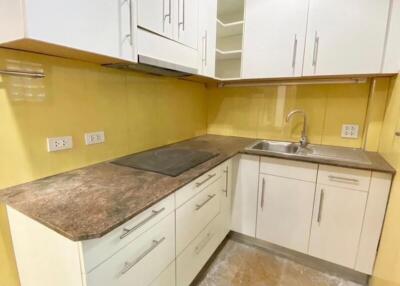 Modern kitchen with white cabinets, brown countertop, sink, and stove