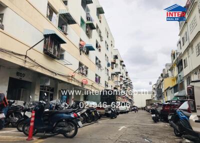 Apartment complex with multiple floors and parked motorbikes in front