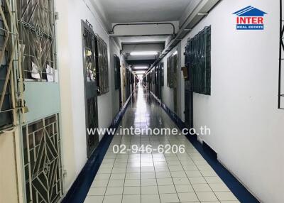 Long hallway in a building with secured doors and tiled floor
