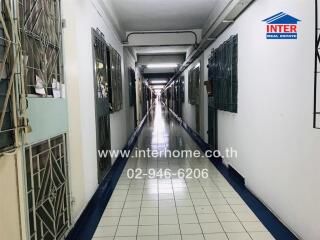 Long hallway in a building with secured doors and tiled floor