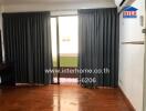 Living room with hardwood floor and large window with curtains