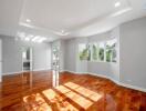 Spacious living room with wooden flooring and large windows