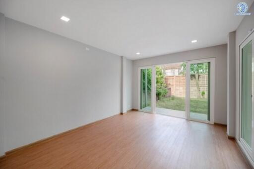 Spacious living room with hardwood floors and large sliding glass doors leading to a backyard.