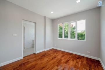 Empty bedroom with wooden floors and large windows