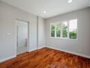 Empty bedroom with wooden floors and large windows