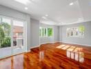 Spacious living room with large windows and wooden flooring