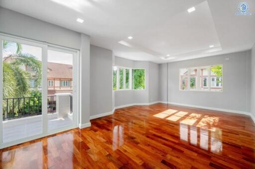 Spacious living room with large windows and wooden flooring