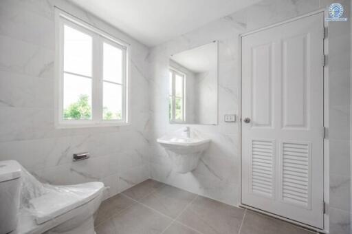 Modern bathroom with large windows, a wall-mounted sink, and a toilet